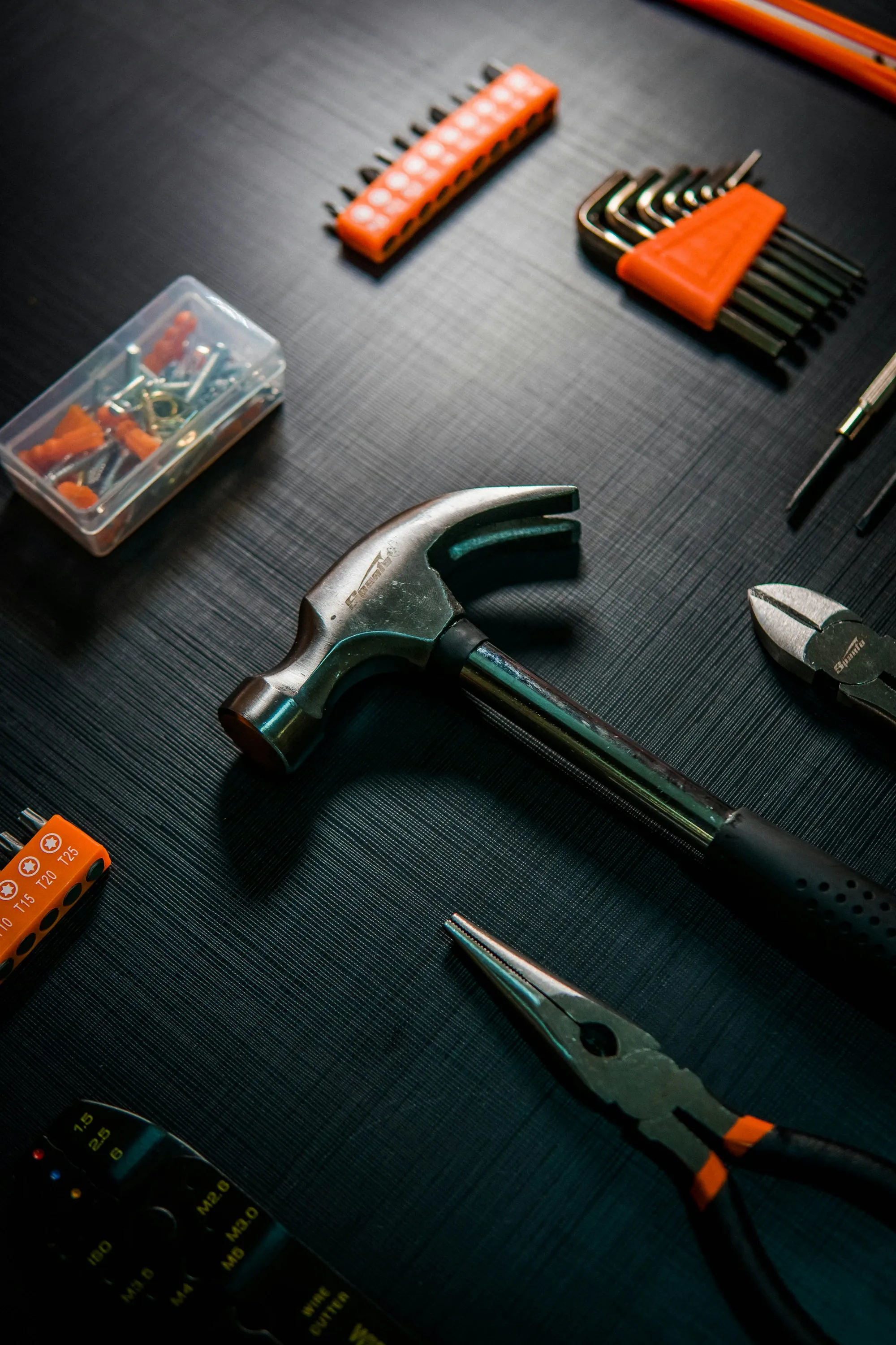 Hammer and pliers on a dark textured surface