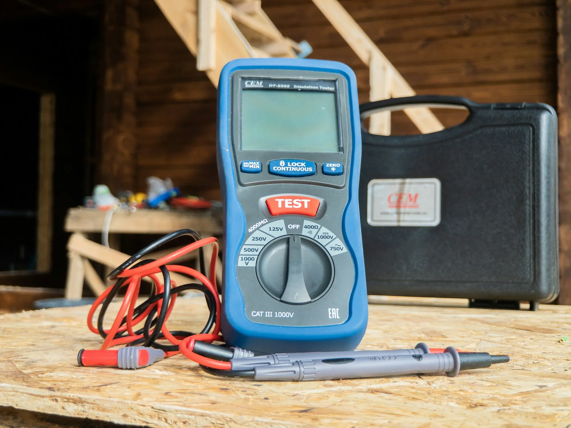Blue multimeter and test leads on a workbench